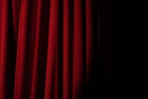 Elegant red velvet curtain with dramatic lighting perfect for theater themes.